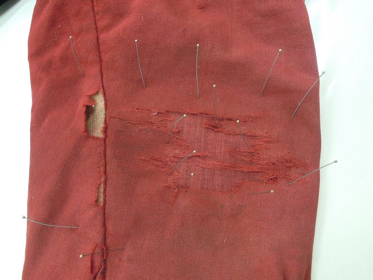 giacca costume n°6 durante l'intervento di restauro, dettaglio consolidamento di una zona lacerata in adesione con velo di Lione e fermatura a cucito - ph.: R.T. Restauro Tessile